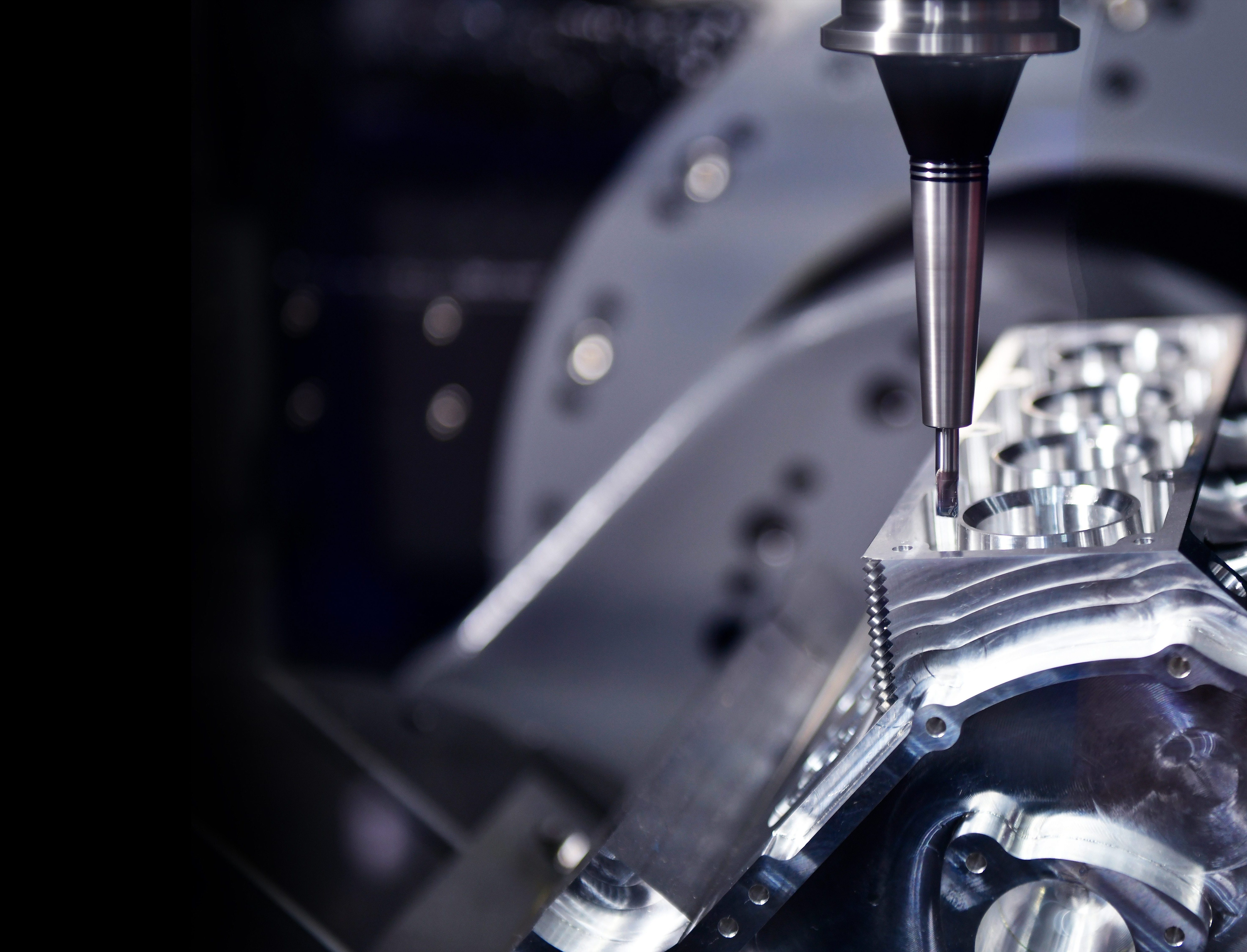 The 5-axis machining center cutting the engine cylinder block with solid ball end mill tool. Hi-precision automotive manufacturing process by multi-axis CNC milling machine.