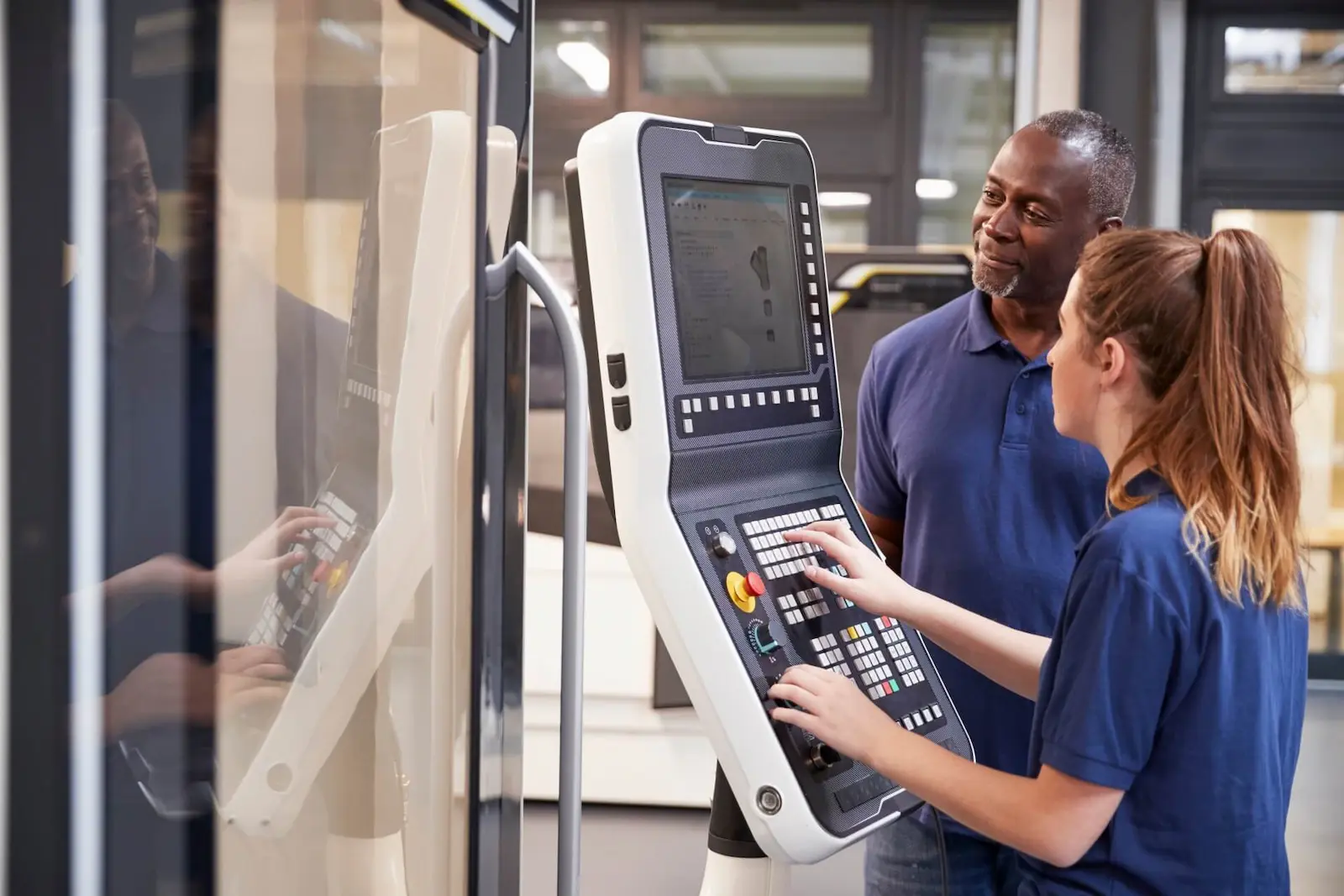 Experienced machinist mentoring a newer team member